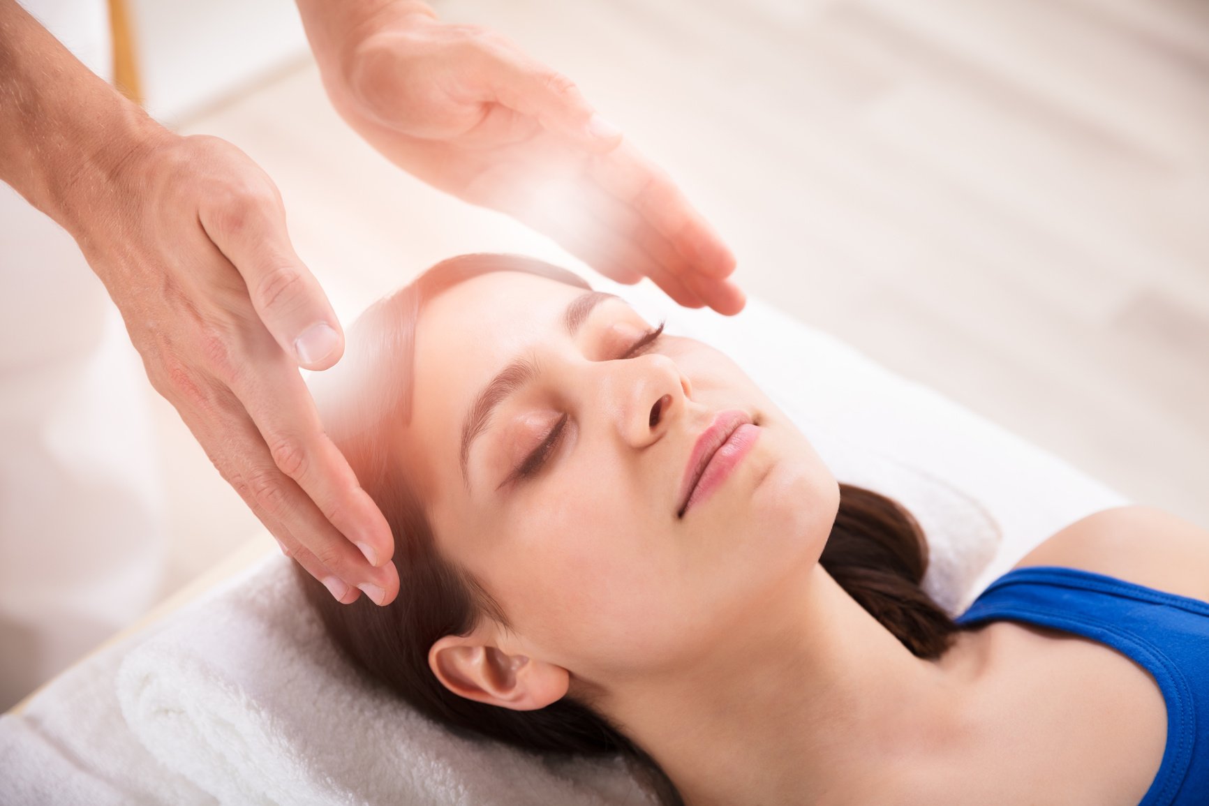 Therapist Performing Reiki Healing Treatment On Woman